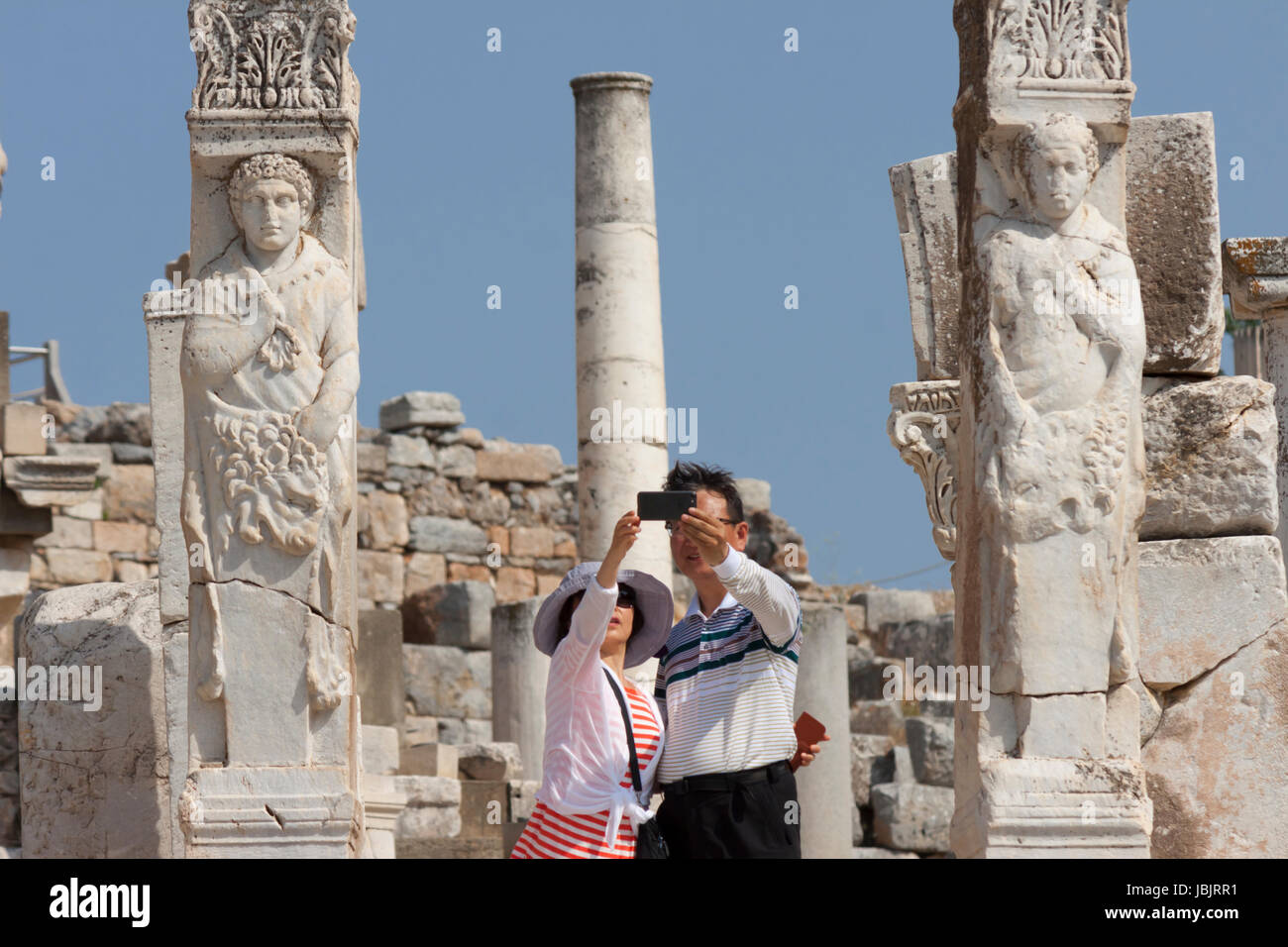 I turisti tenendo selfie presso la Porta Ercoleta nell'antica città di Efeso (Turchia) Foto Stock