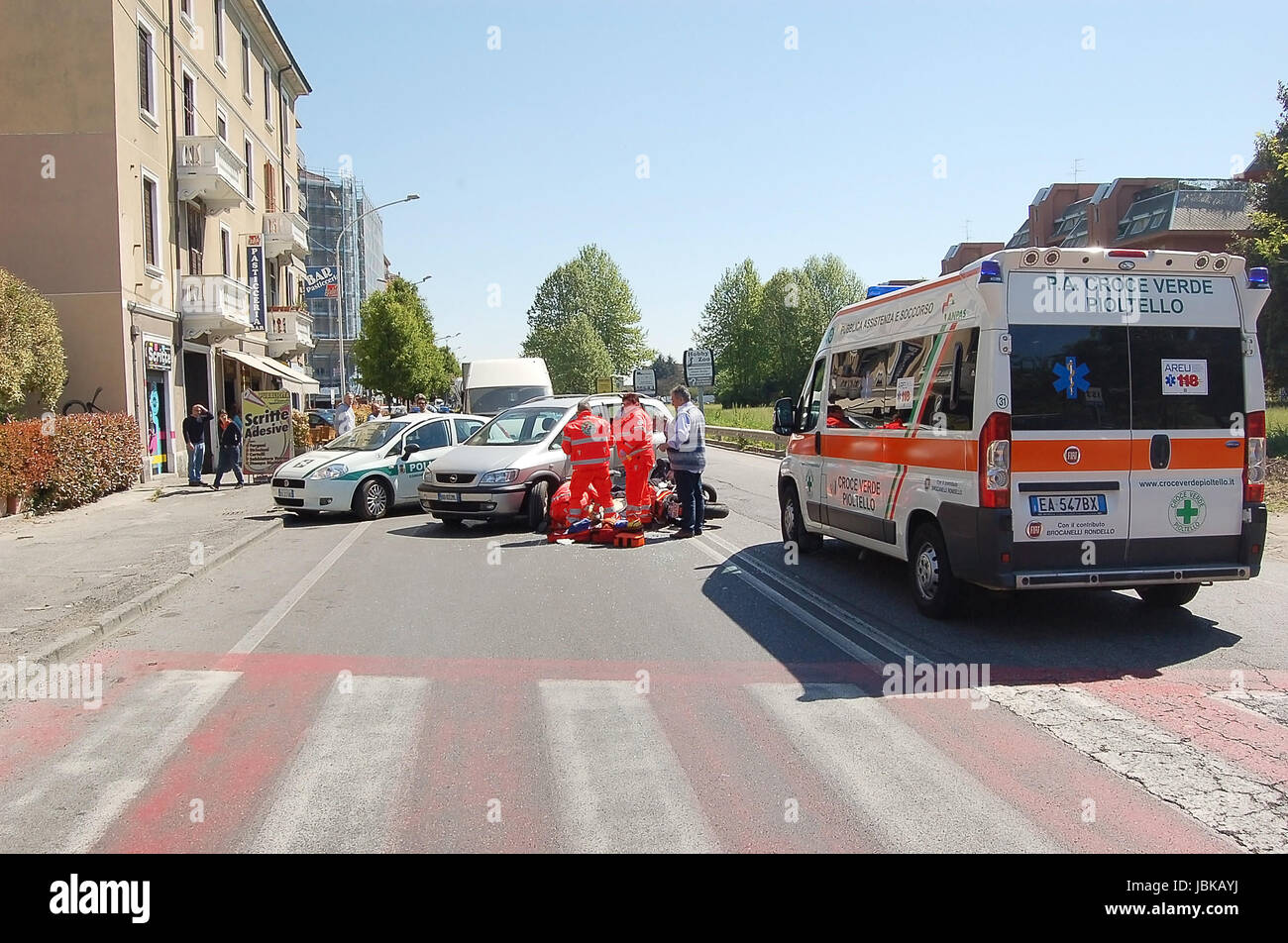 Un gruppo di para-professionale di personale medico è di fornire una risposta rapida alle cure mediche dopo un traffico urbano collisione in Milano area urbana, Italia Foto Stock