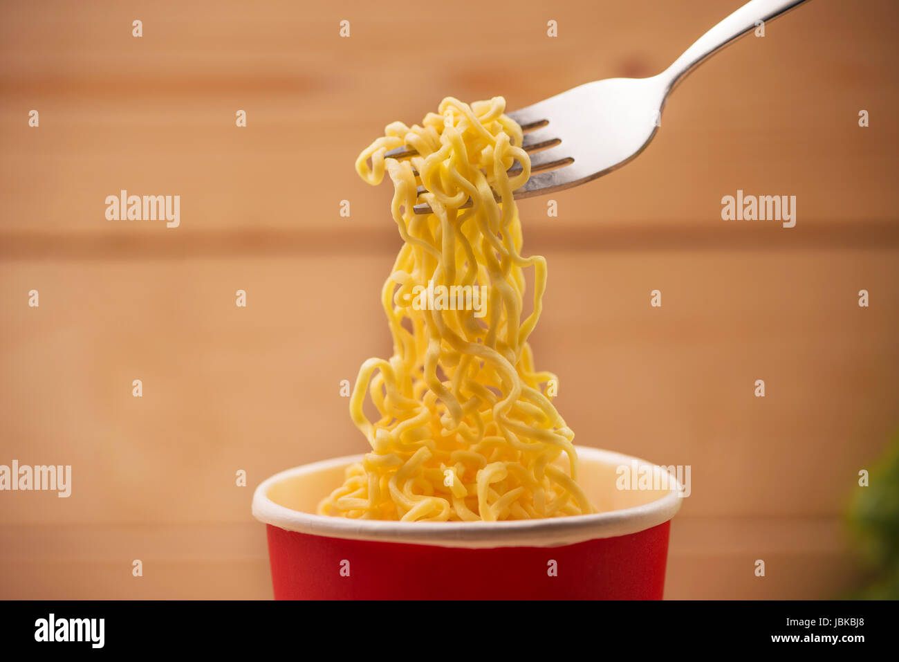 Mangiare spaghetti istantanei in tazza con una forcella Foto Stock