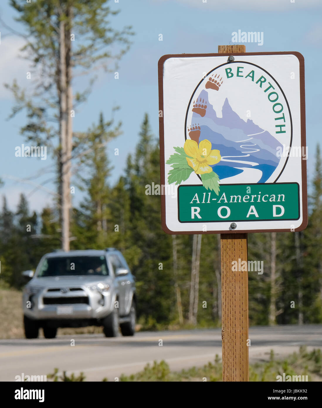 Un veicolo passa un cartello stradale su la Beartooth Highway, tutti American road tra Red Lodge e Cooke City. Foto Stock