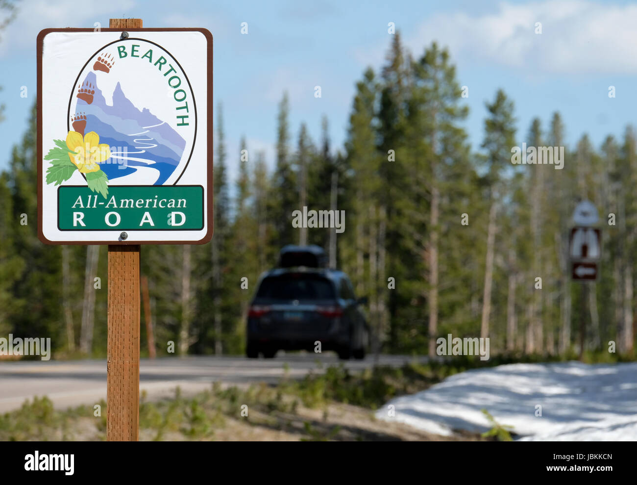 Un veicolo passa un cartello stradale su la Beartooth Highway, tutti American road tra Red Lodge e Cooke City. Foto Stock
