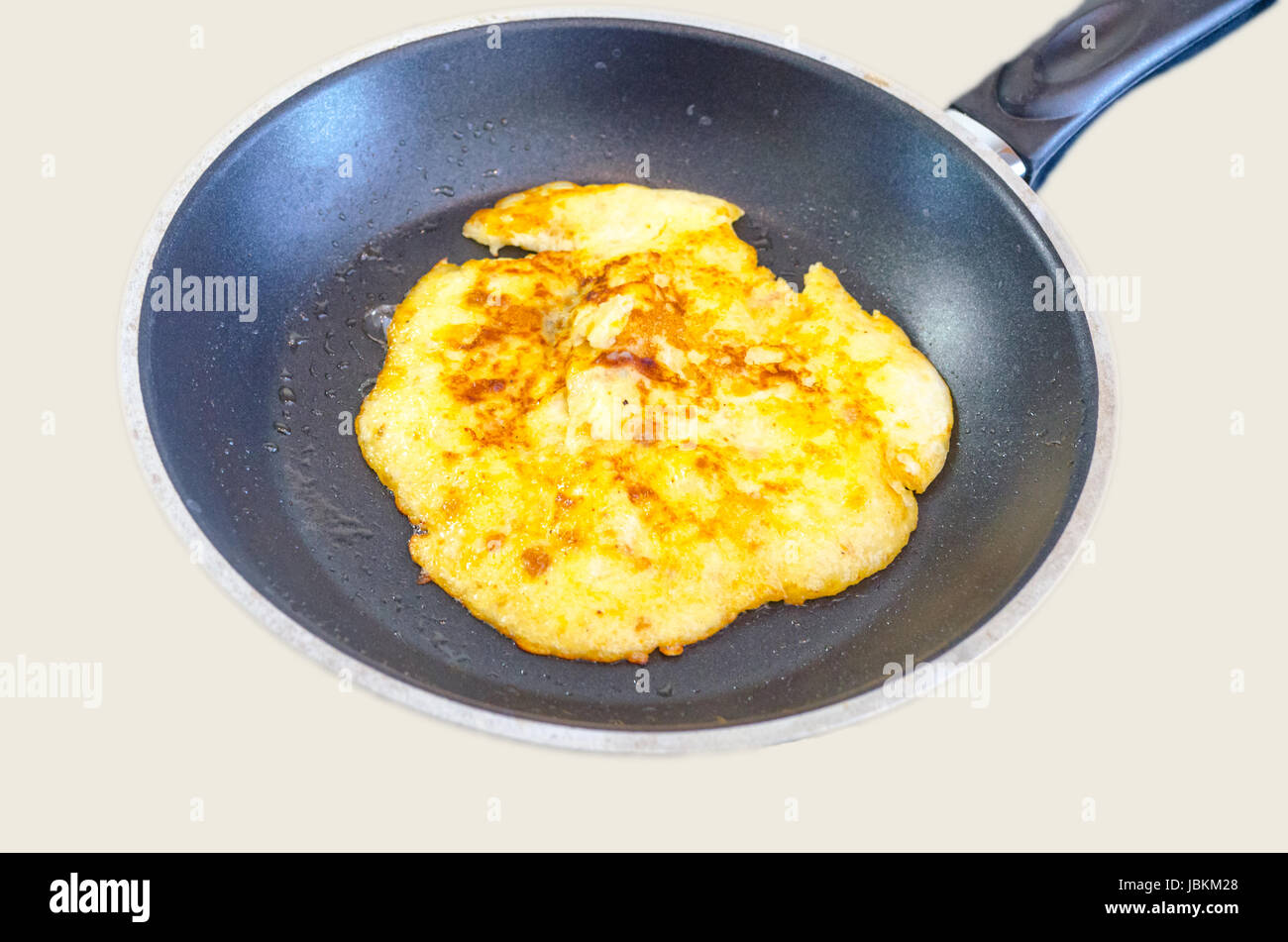 Eierpfannkuchen, Omlett in einer Pfanne vor einem hellen Hintergrund Foto Stock