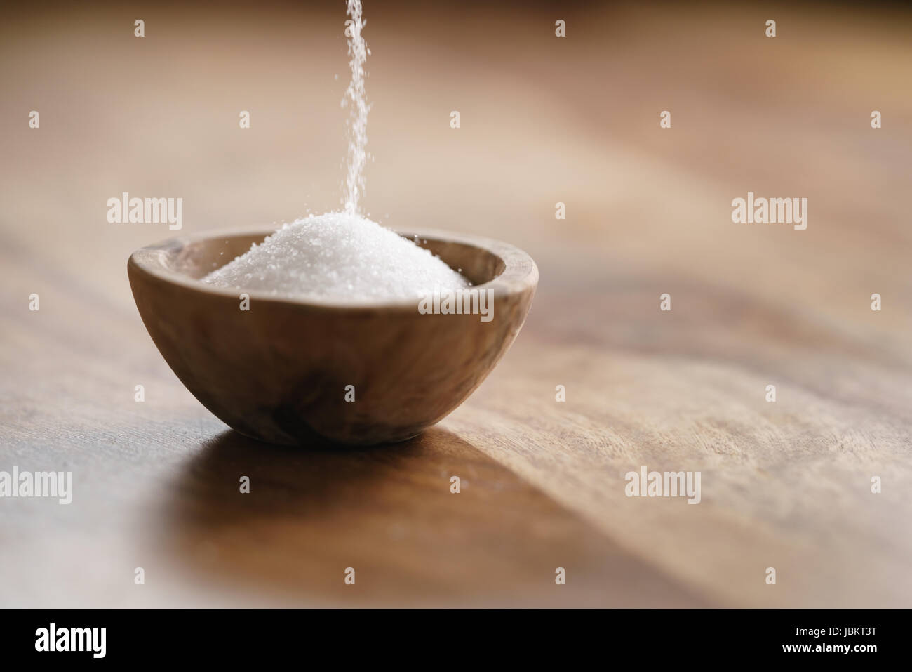 Mare extra sale versare nel recipiente di legno sul tavolo di legno Foto Stock