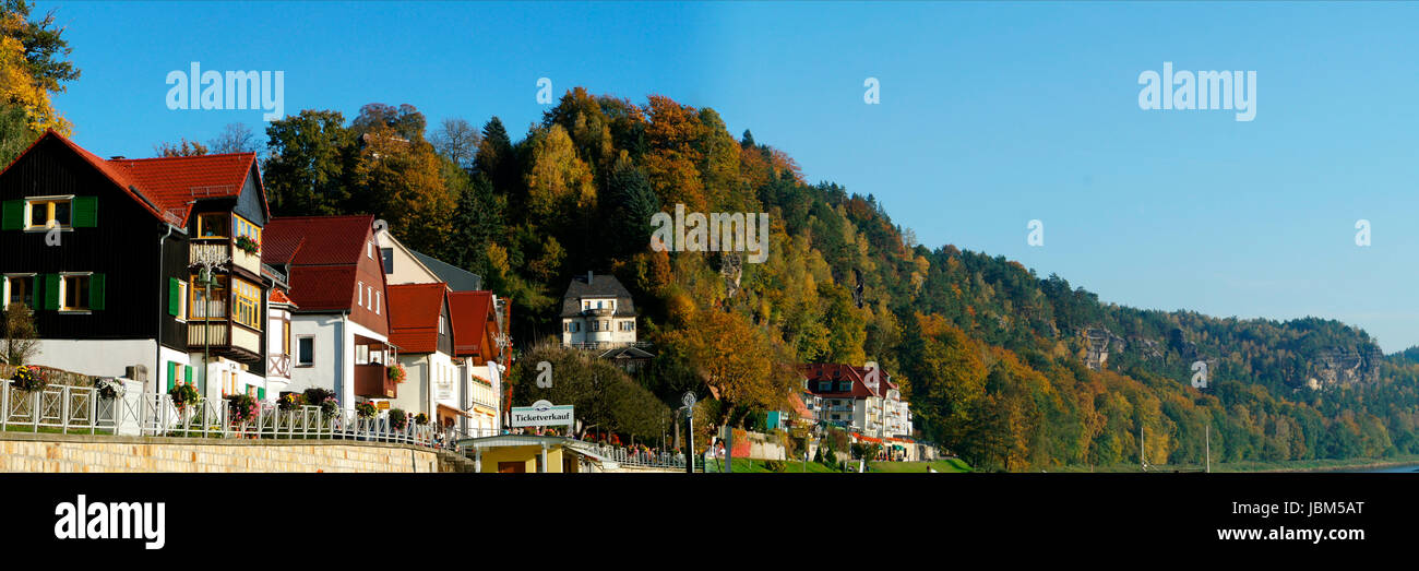 Idyllischer Kurort an der Elbe in der Sächsischen Schweiz in Deutschland, schöne Häuser, die bizarren Felsformationen und bunte Laubwälder, panorama idilliaco cittadina termale sull'Elba nella Svizzera sassone in Germania, belle case e le formazioni rocciose bizzarre e coloratissimi boschi di latifoglie, panorama Foto Stock