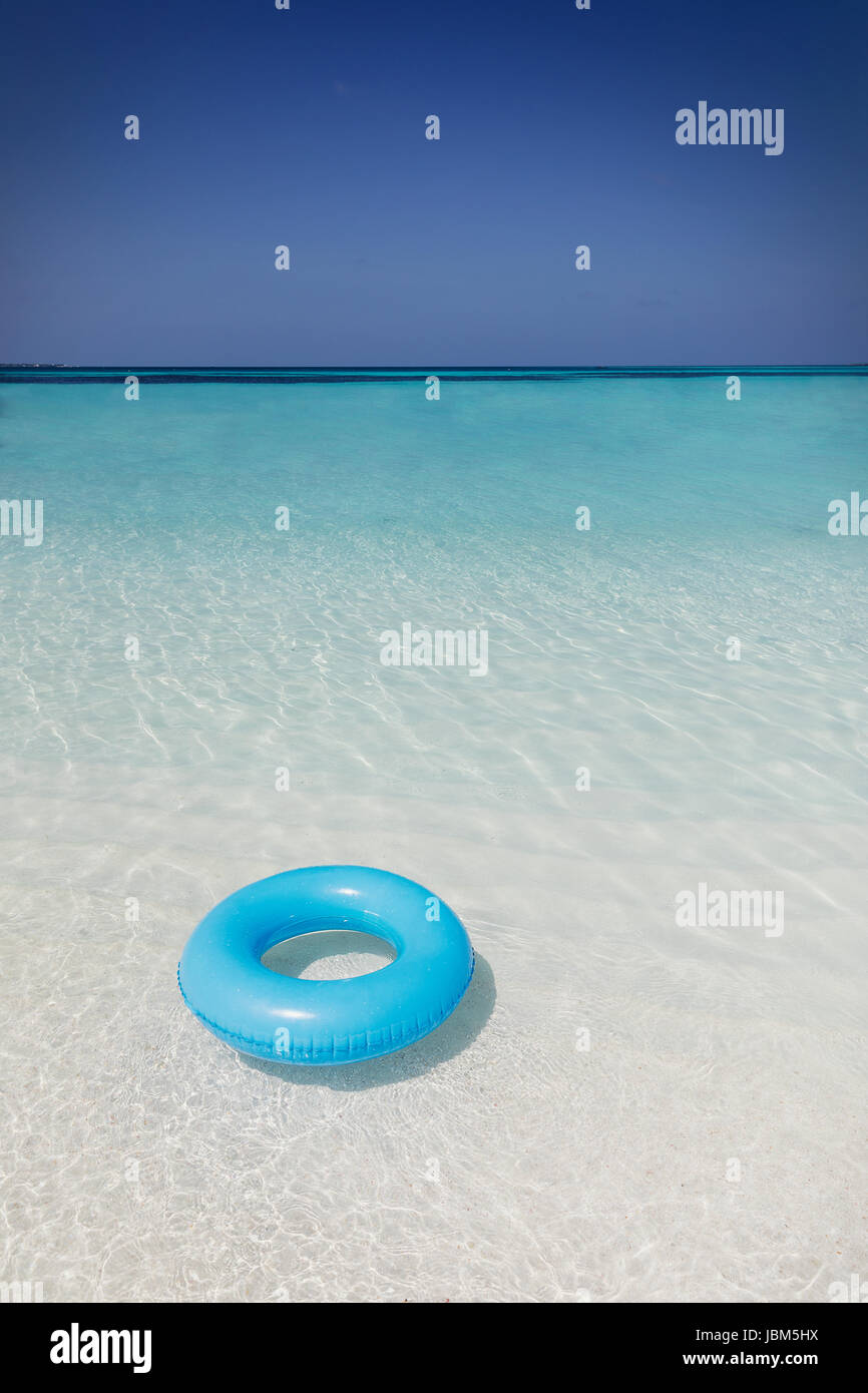 Blu anello gonfiabile galleggianti in oceano tropicale Foto Stock