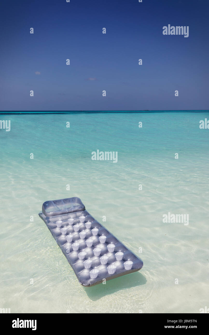 Zattera gonfiabile galleggiante sul tranquillo blu oceano tropicale Foto Stock