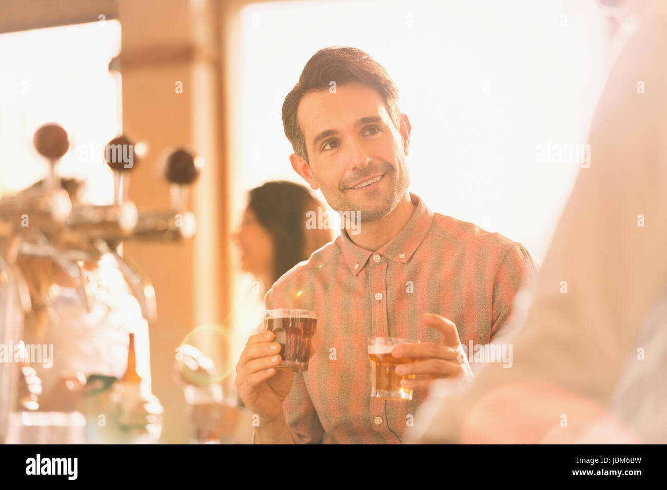 Uomo sorridente il campionamento birra al bar Foto Stock