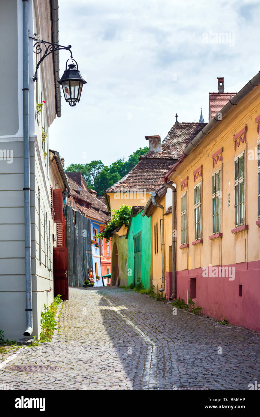 Sighisoara, Romania - 23 Giugno 2013: strada lampada su pietre antiche strade lastricate con casa colorata da Sighisoara fortresss, Transilvania, Romania Foto Stock