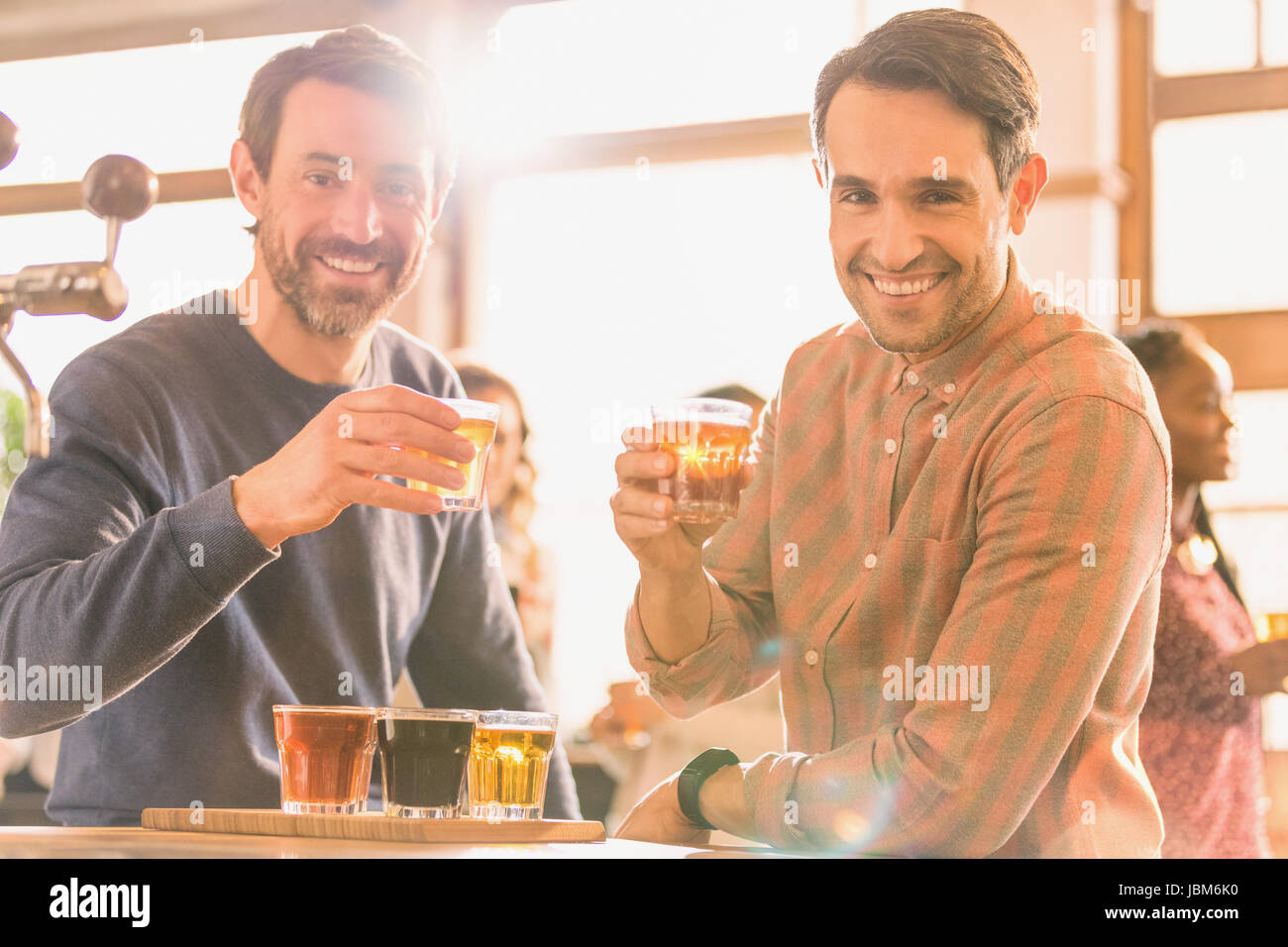 Ritratto uomini sorridenti amici della birra di campionamento a microbirreria bar Foto Stock