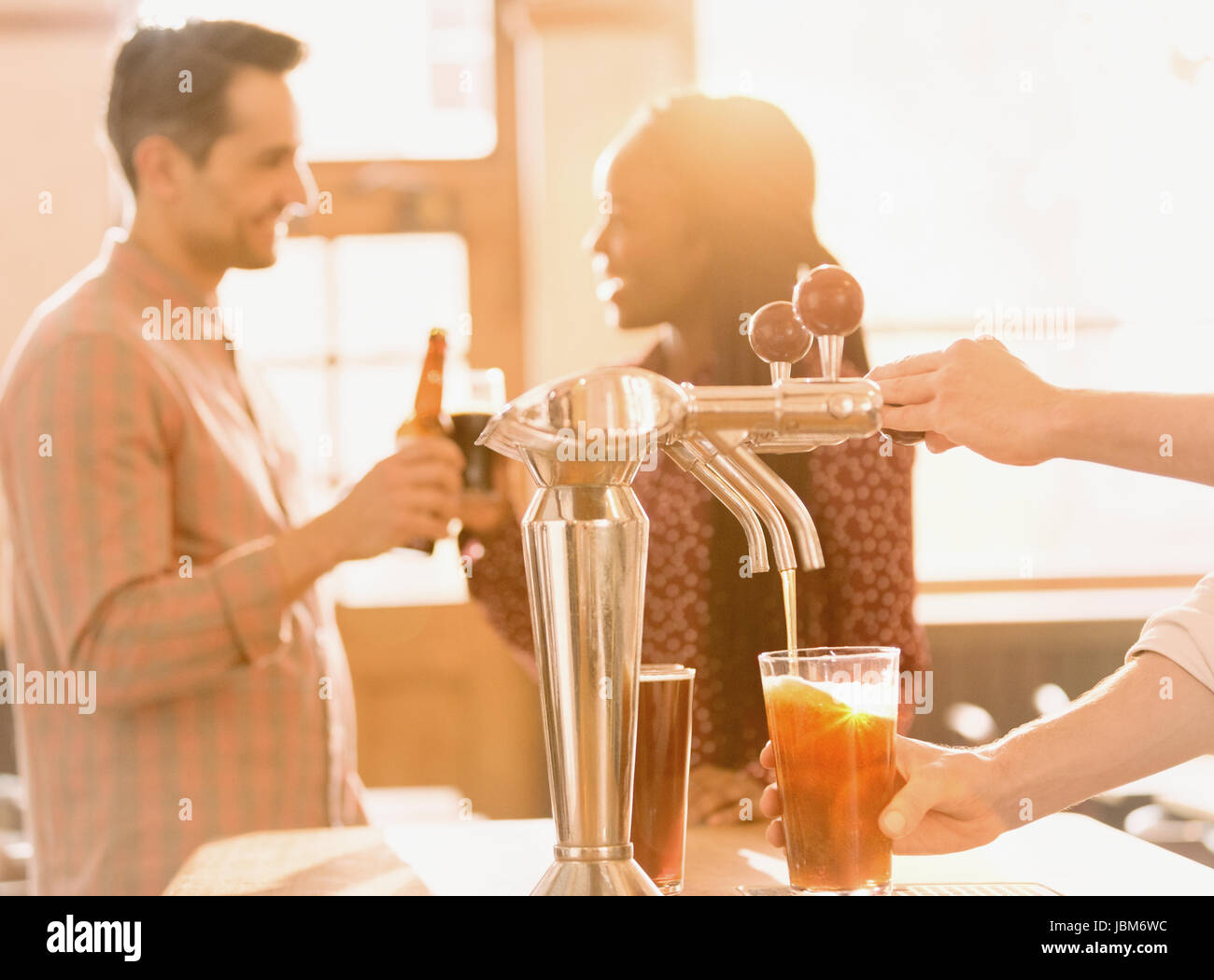 Paio di bere birra dietro il barista a versare birra birra a toccare in bar Foto Stock