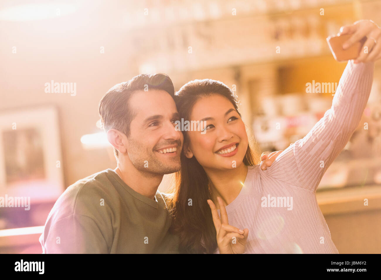 Coppia sorridente gesti segno di pace prendendo selfie con la fotocamera del telefono Foto Stock