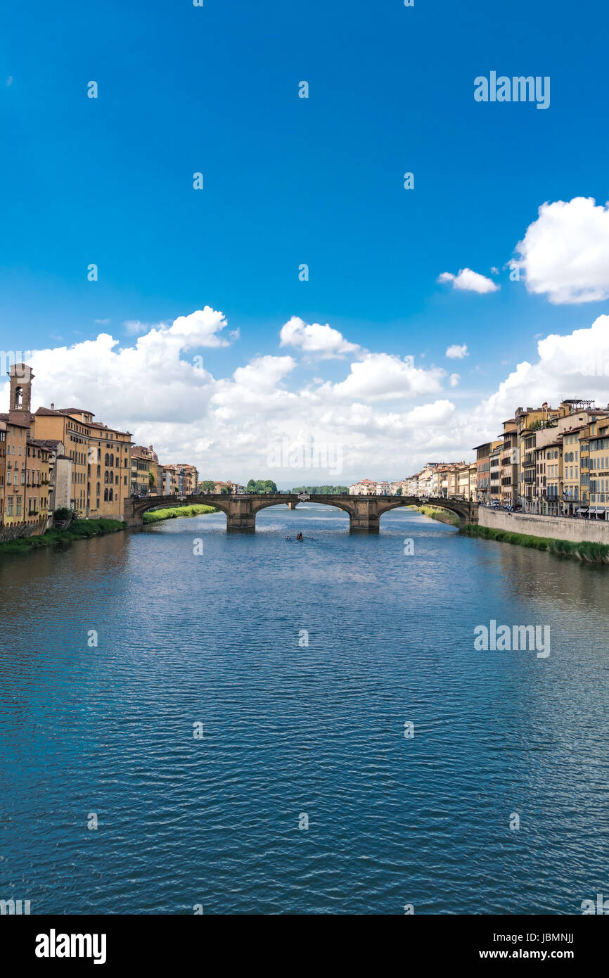 Composizione verticale il fiume Arno a Firenze con puffy nuvole e vogatori sull'acqua. Foto Stock