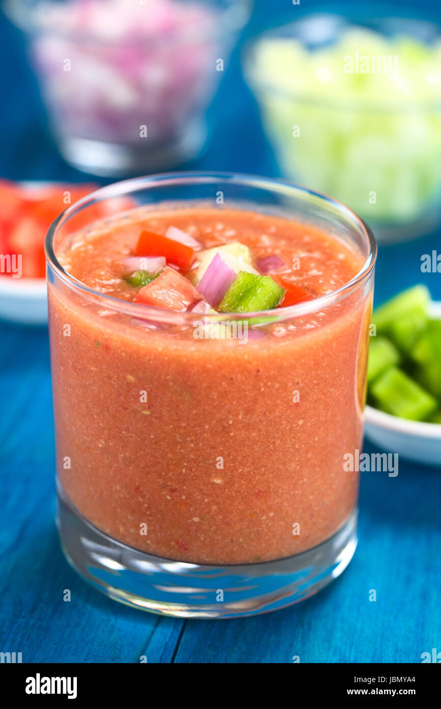 Tradizionale spagnolo di verdura fredda zuppa di pomodoro, cetriolo, peperone, cipolla, aglio e olio di oliva servito in vetro (messa a fuoco selettiva, messa a fuoco sulla parte anteriore delle verdure sulla parte superiore della zuppa) Foto Stock