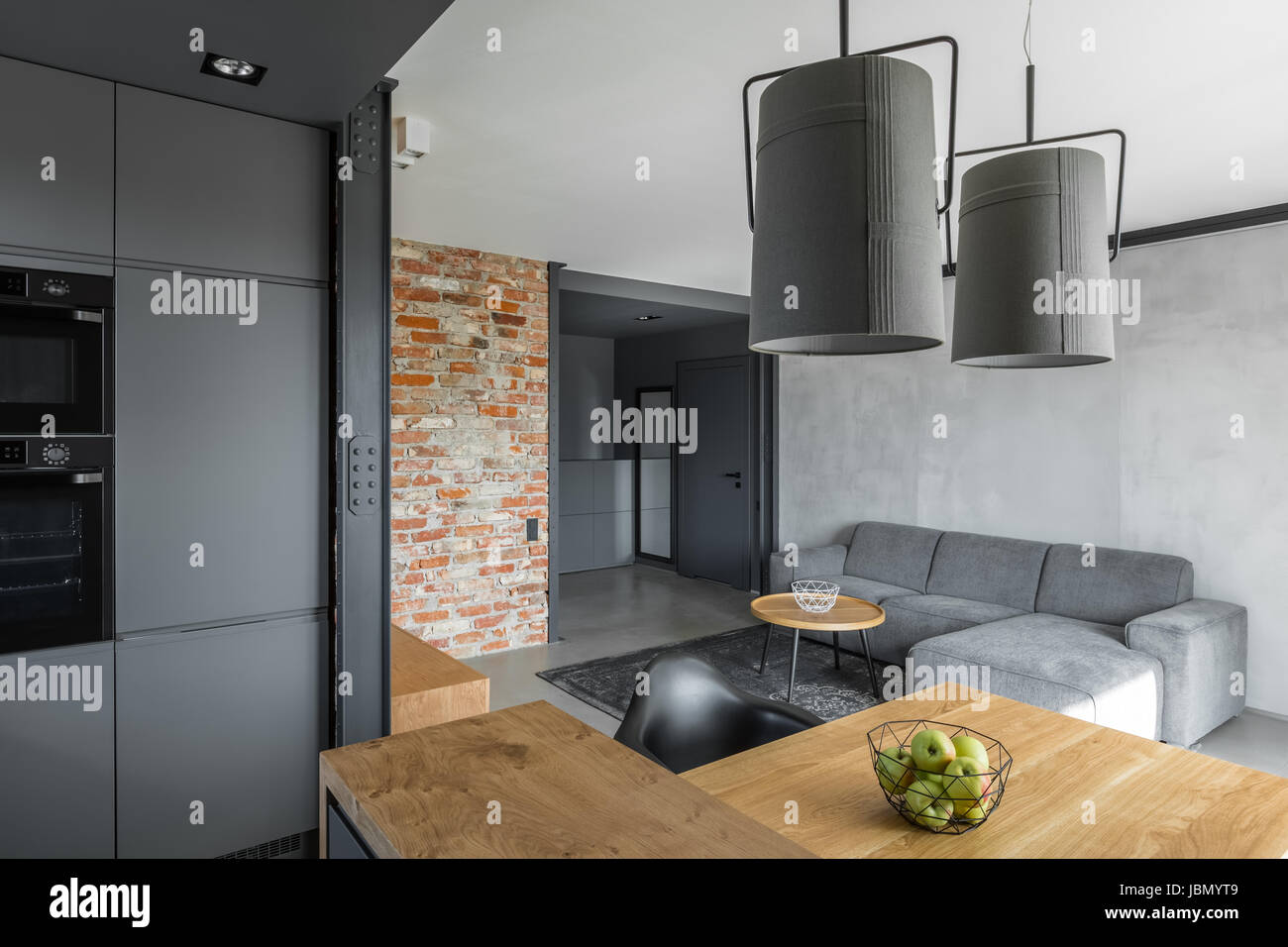 Home interno con pareti di mattoni e cucina aperta e salotto Foto Stock