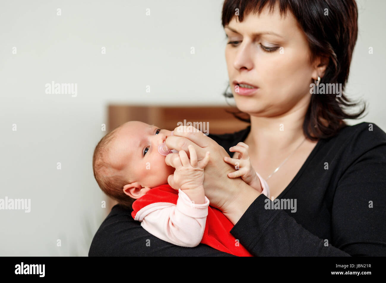 Mamma con il suo piccolo grazioso Baby girl, primo mese della nuova vita, della messa a fuoco per neonati, regolando il succhietto Foto Stock