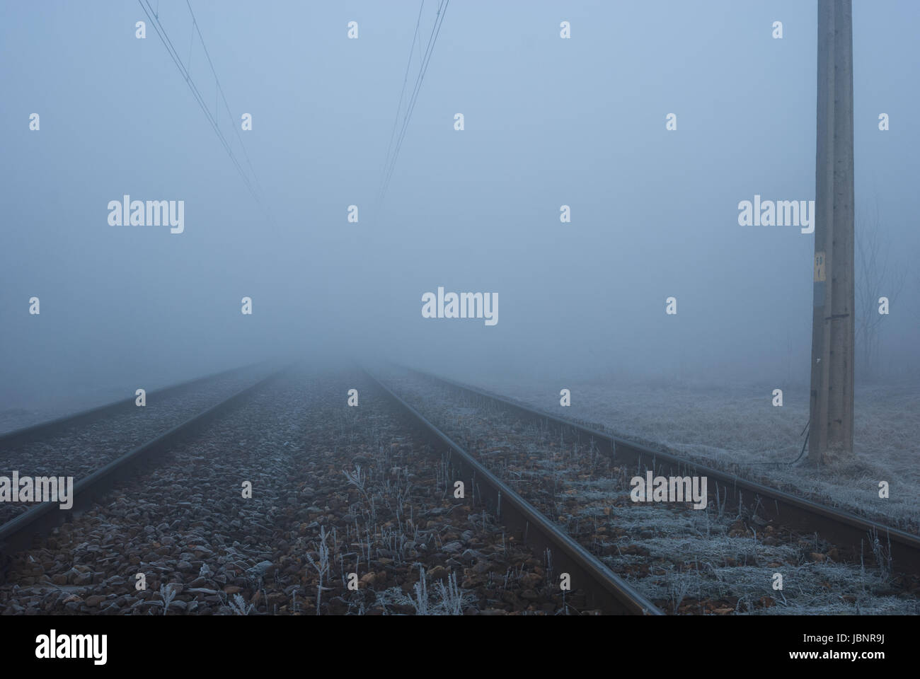 I binari della ferrovia nella nebbia Foto Stock