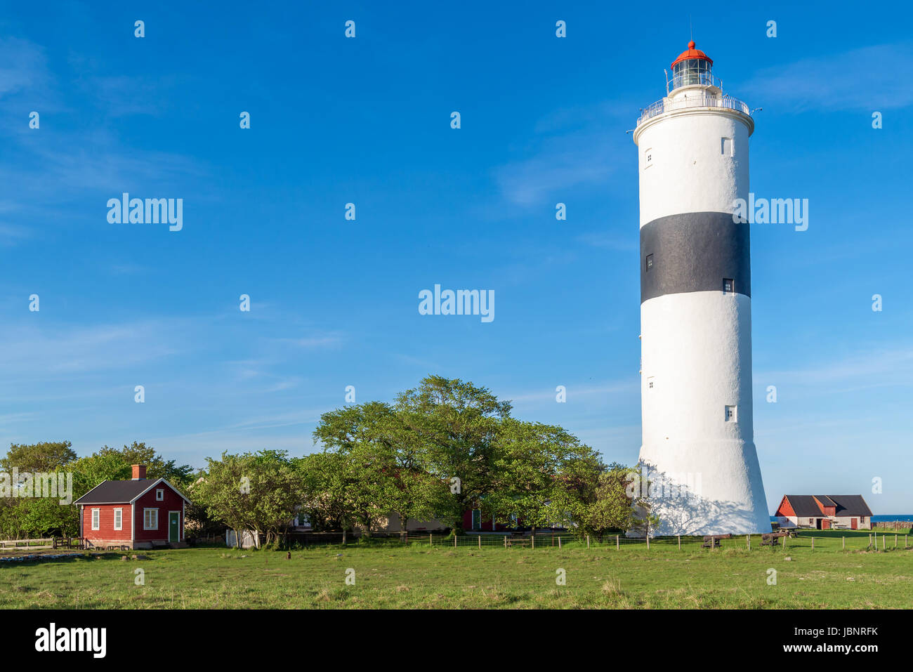 Il faro alto lungo Jan sull'isola Oland in Svezia, visto con il paesaggio circostante e gli edifici su un fine soleggiato sera. Foto Stock
