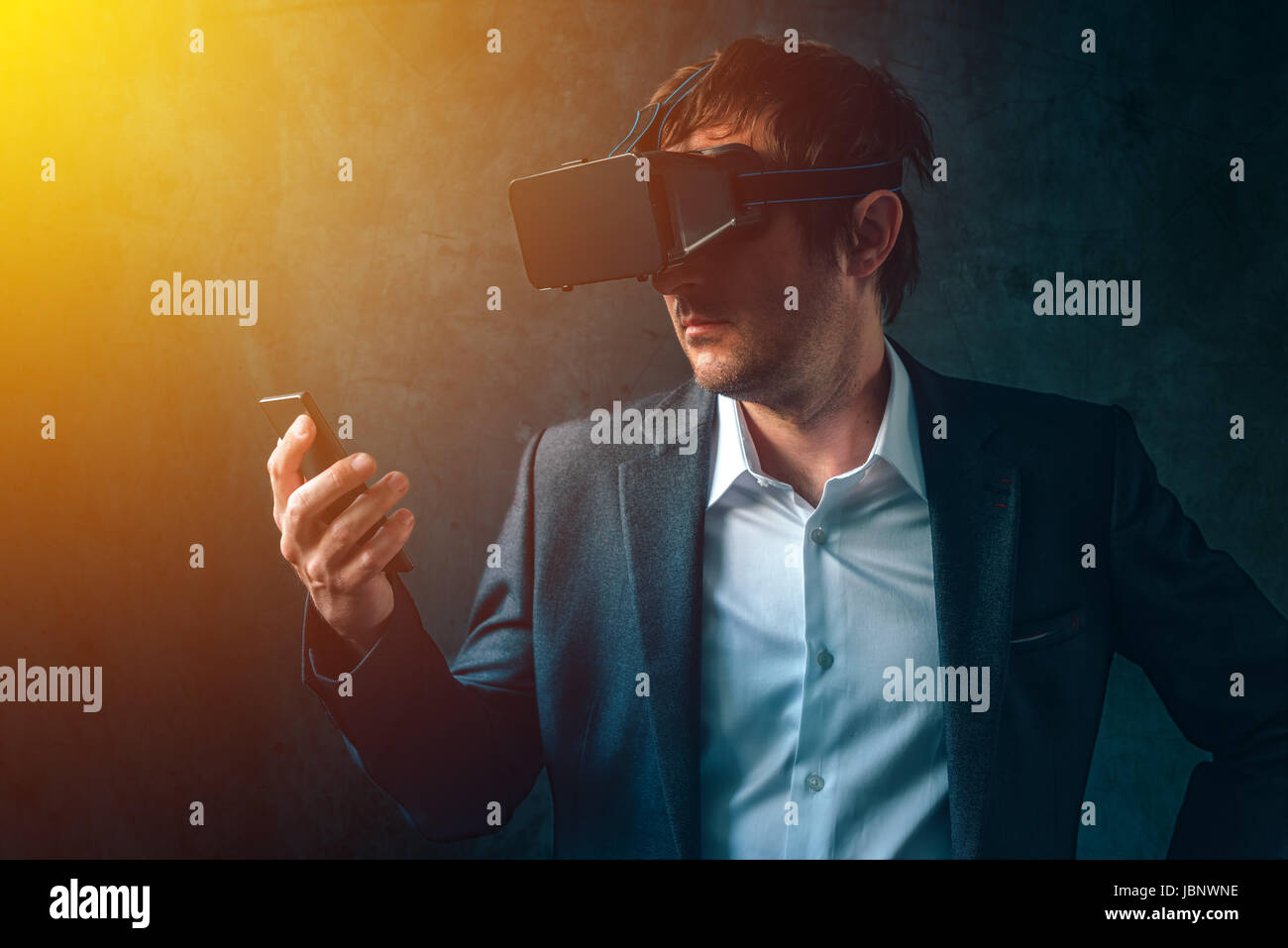 La realtà virtuale e la tecnologia futuristica nelle aziende moderne, imprenditore con VR auricolare e lo smartphone utilizzando la new tech gadget per sviluppare e gestire Foto Stock