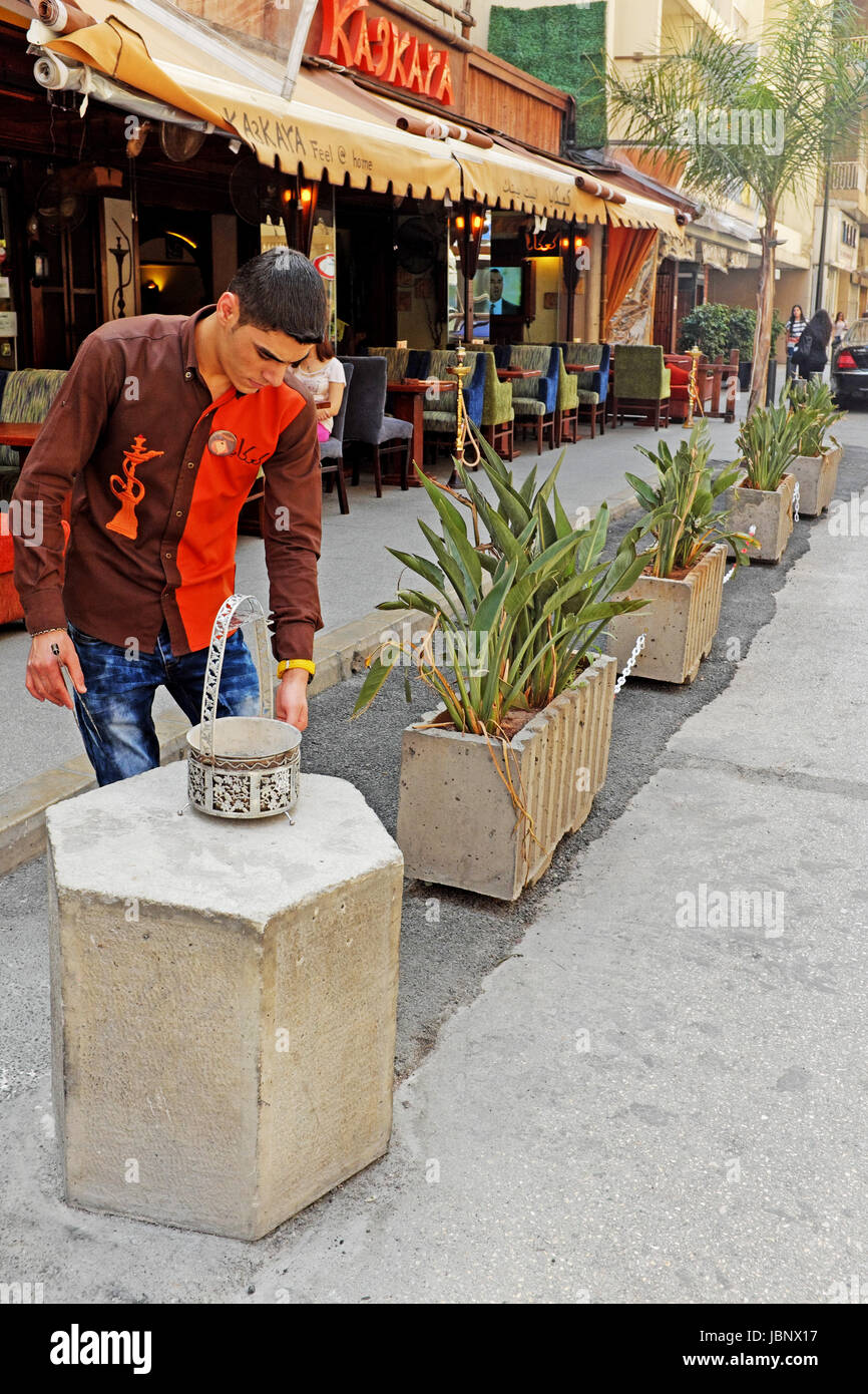 Uno dei tanti caffè nel quartiere di Hamra di Beirut Libano. Il dipendente è la preparazione di carbone utilizzato per ricostituire il pipe shisha. Foto Stock
