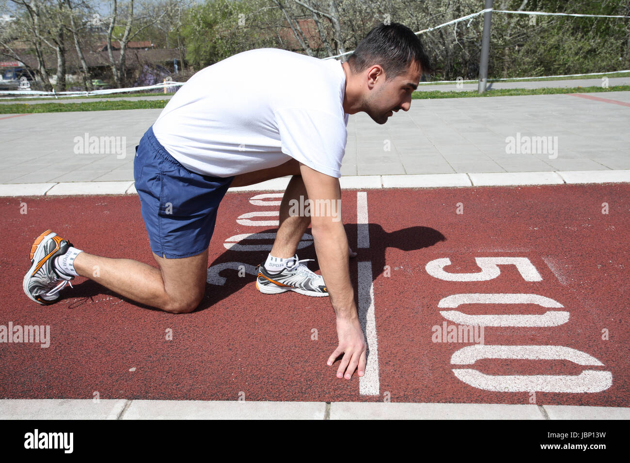 Atleta sulla linea di partenza in attesa di avviare in via di corsa Foto Stock