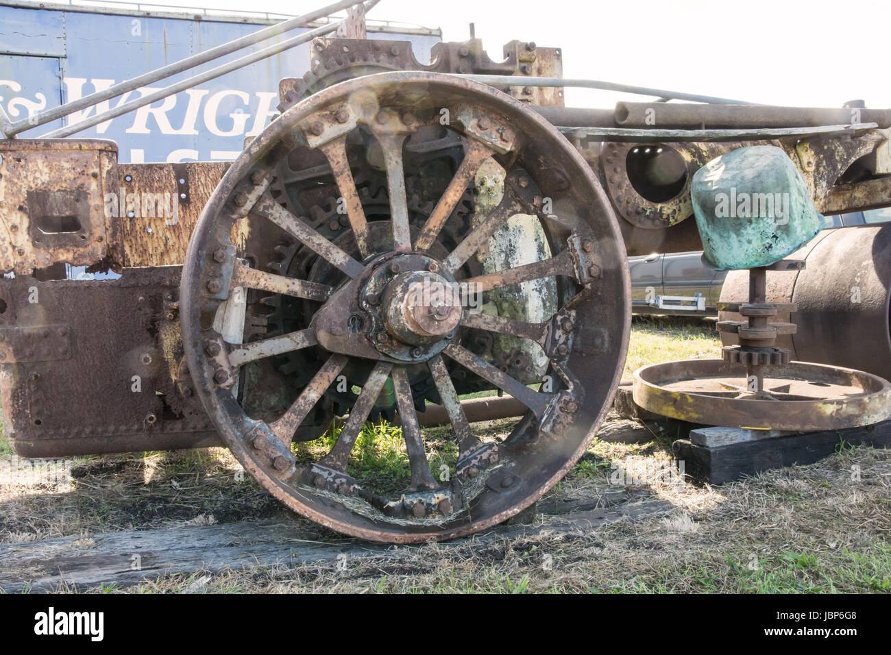Grande Ferro ruggine ruota posteriore di derelitti 1926 John Fowler 10 ton rullo di vapore in un cimitero del veicolo. Foto Stock