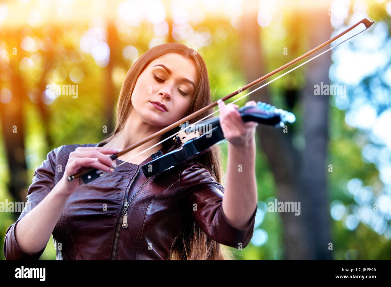 Donna eseguire brani musicali sul violino in parco all'aperto. Ragazza  eseguire jazz sulla strada di