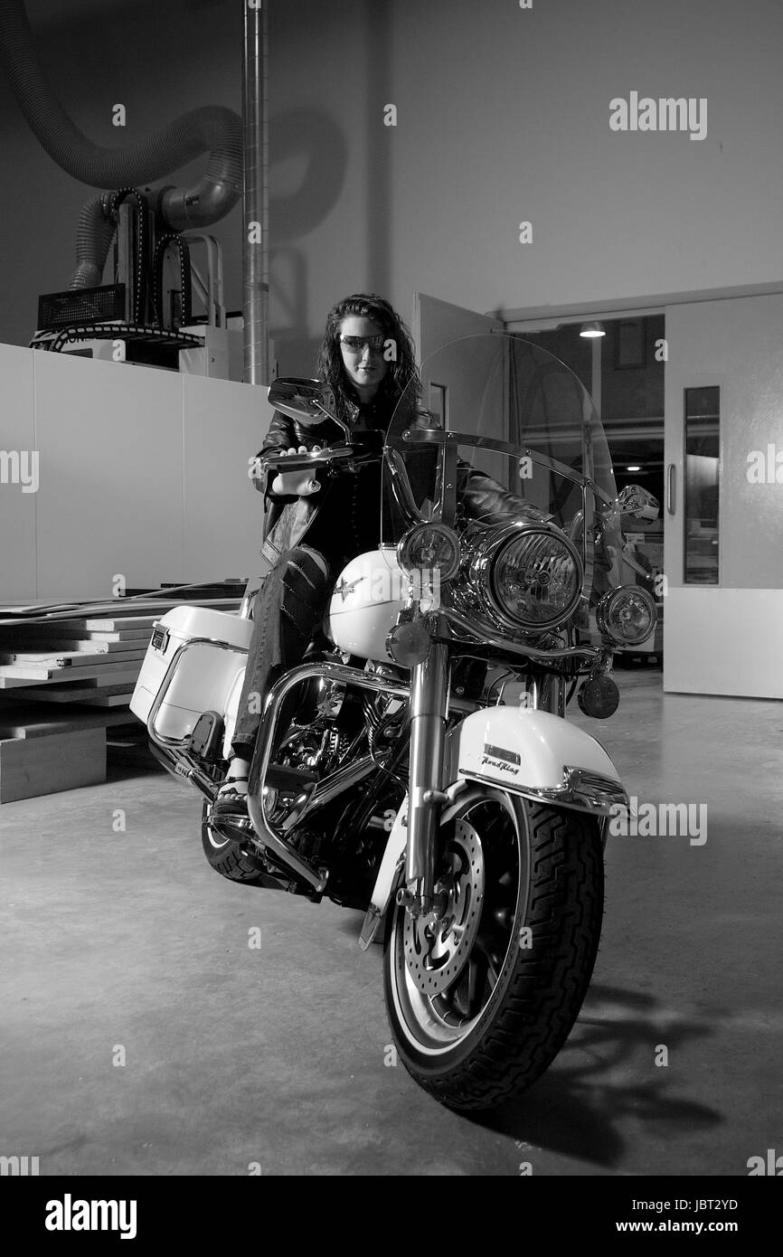 Bella bruna ragazza su una Harley Davidson Road King moto posizione interna Foto Stock
