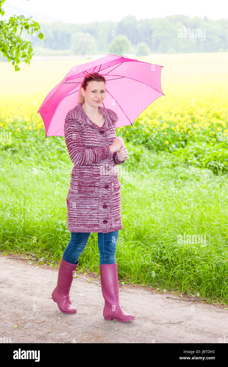 Donna di indossare stivali di gomma con Ombrello in primavera la natura  Foto stock - Alamy