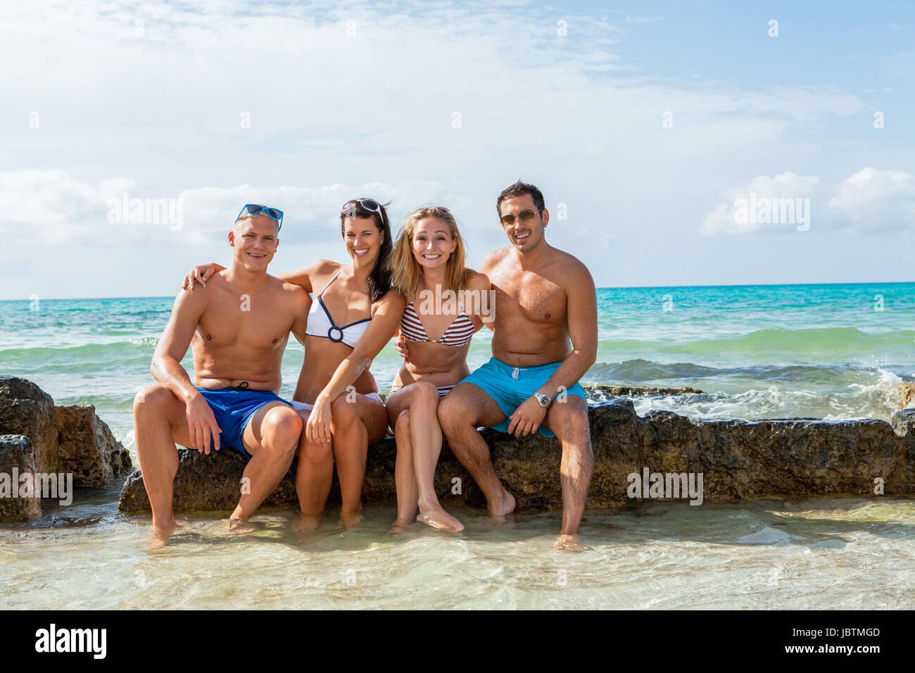 Gruppe lachender junger leute am Strand im sommer urlaub freizeit lifestyle Foto Stock