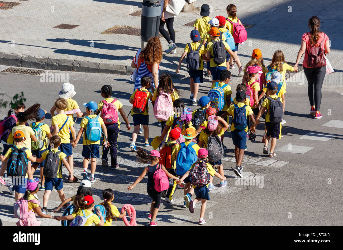 I bambini della scuola attraversando un semaforo Foto Stock