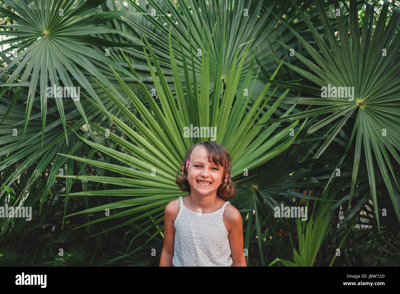 La ragazza di fronte alla ventola Palm tree Foto Stock