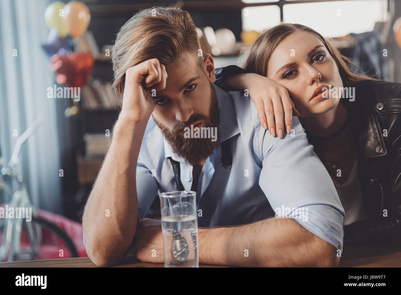 Uomo e donna con i postumi della sbornia con farmaci in disordine in camera dopo il party Foto Stock