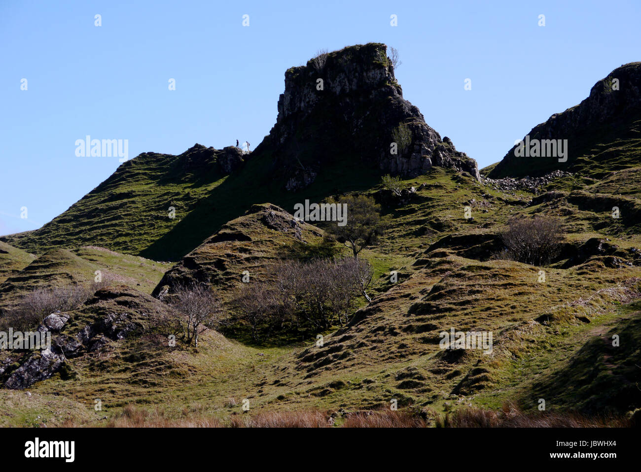 Due persone vicino alla torre rocciosa del castello di Ewen & la conformata a cono collinette in Fairy Glen, Uig, Isola di Skye,North West Highland scozzesi,Scozia. Foto Stock