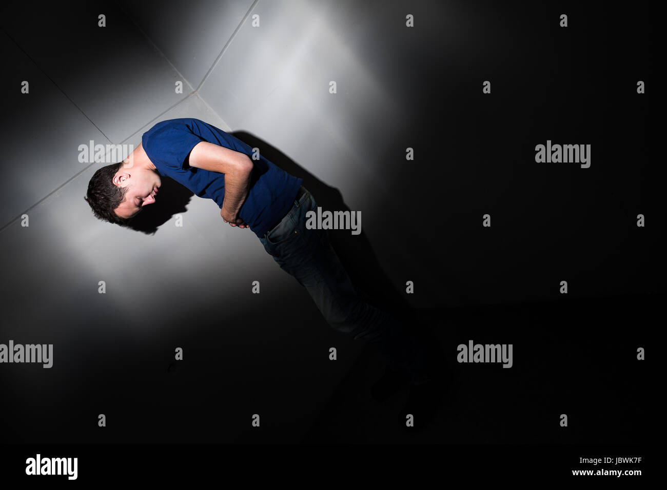 Giovane uomo che soffre di gravi dolori di pancia, di essere monopolizzati dalla condizione debilitante di malattia celiak/morbo di Crohn Foto Stock