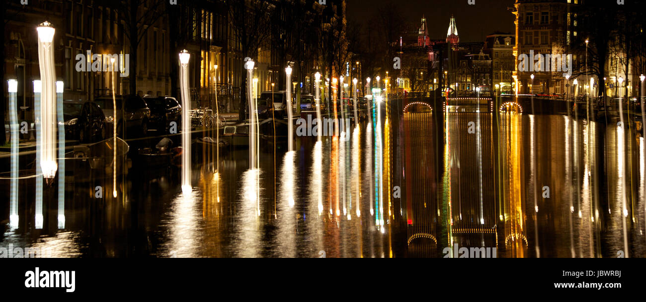 Amsterdam di notte, paesaggio luci riflettendo off canal Foto Stock