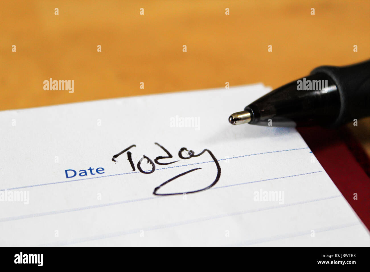 Un primo piano del blocco note con la punta di una penna e le parole oggi scritte per la data. Foto Stock