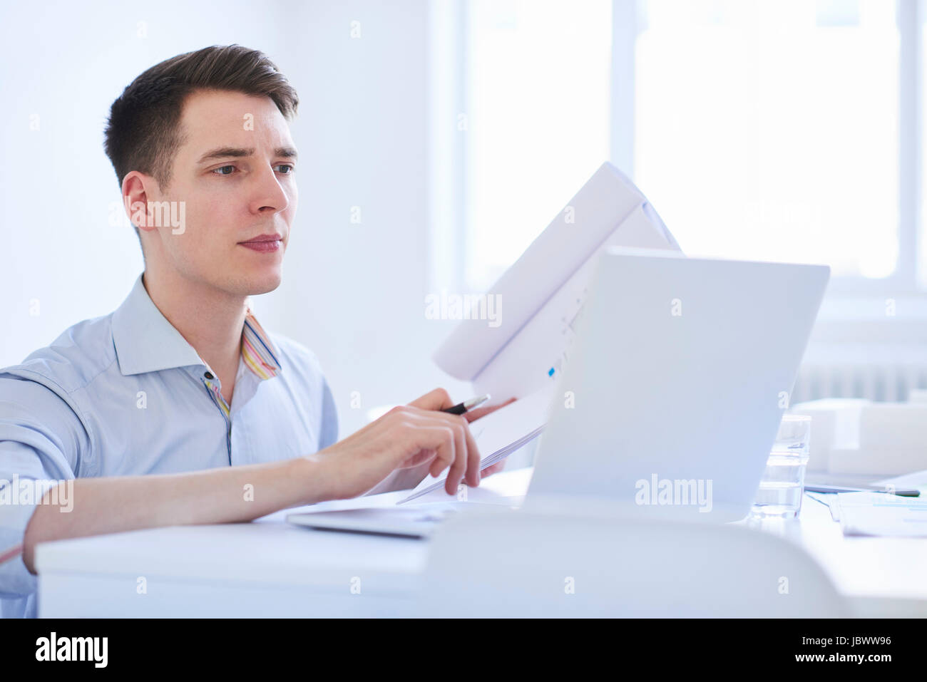 Uomo in ufficio utilizzando tavoletta digitale Foto Stock
