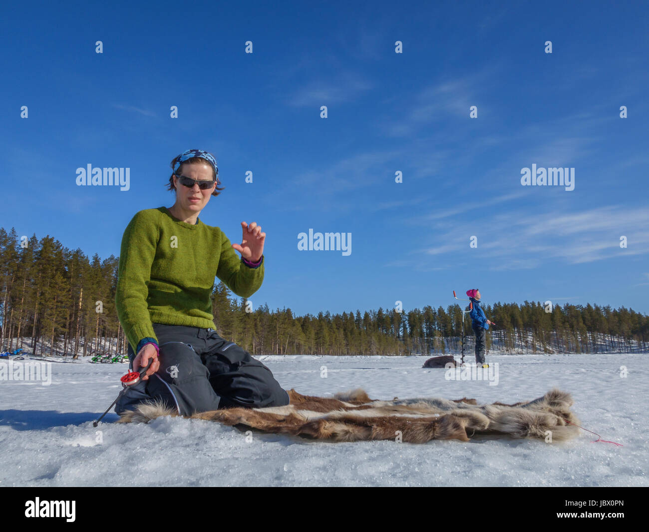 Pesca sul ghiaccio, Kangos, Lapponia, Svezia Foto Stock