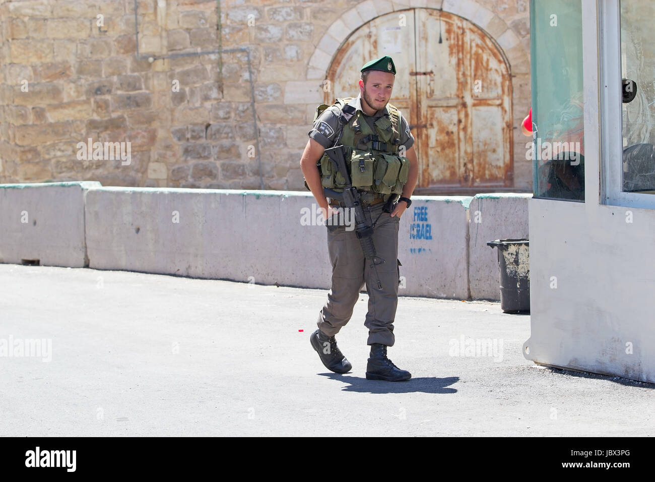 Soldato israeliano con il fucile di assalto al check point tra ebrei e territorio territorio palestinese a Hebron Foto Stock