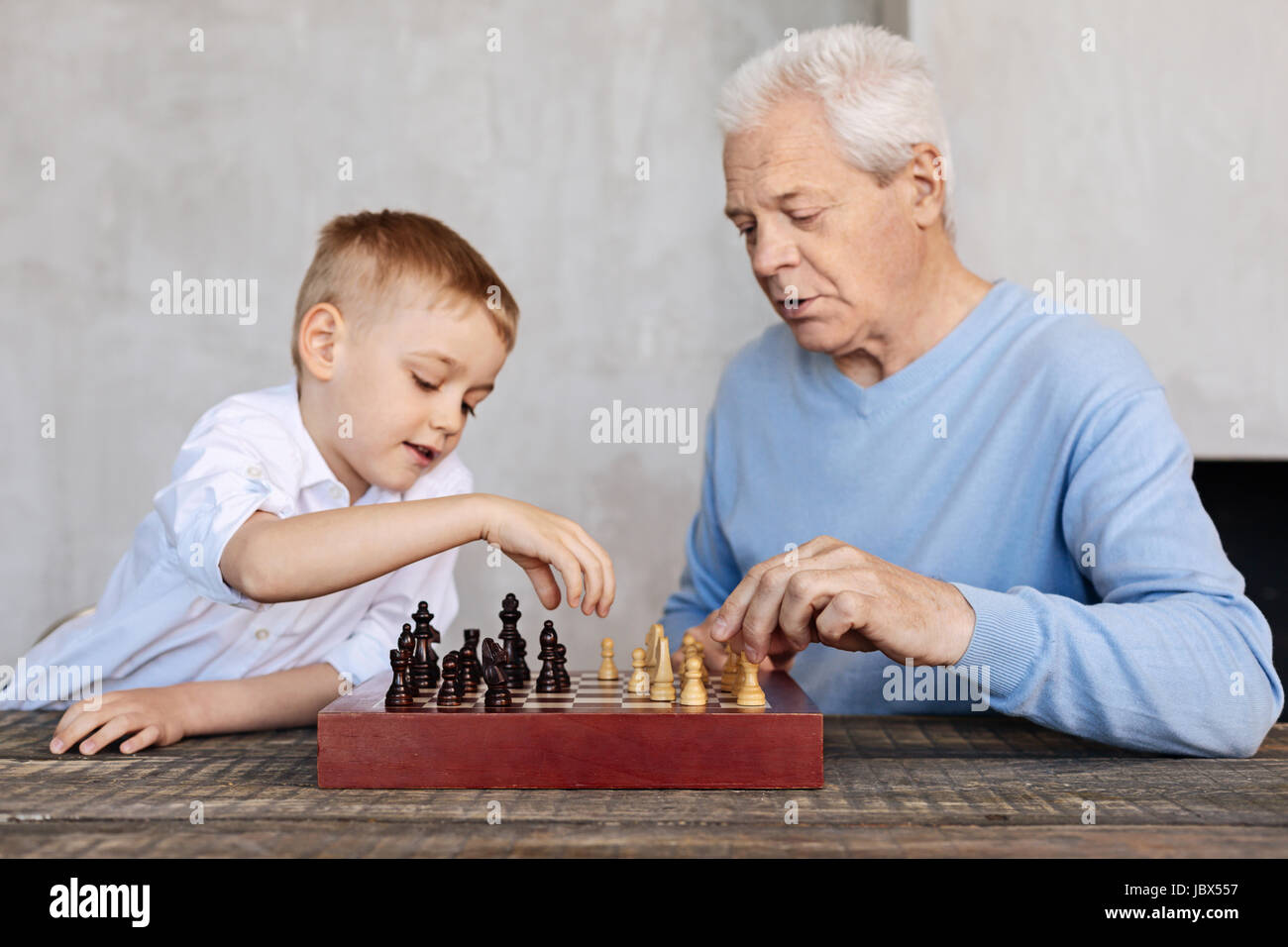 Carino kid e il suo nonno giocando a scacchi Foto Stock