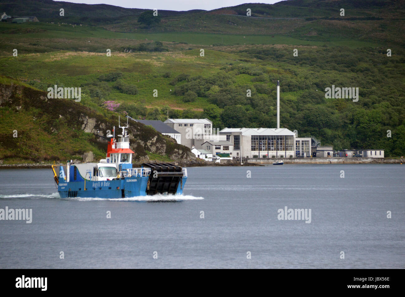 Il Islay per Jura traghetto (Eilean Dhiura) arrivando a Feolin con il Caol Ila distilleria di whisky in background. Isle of Jura, Isole scozzesi. Foto Stock