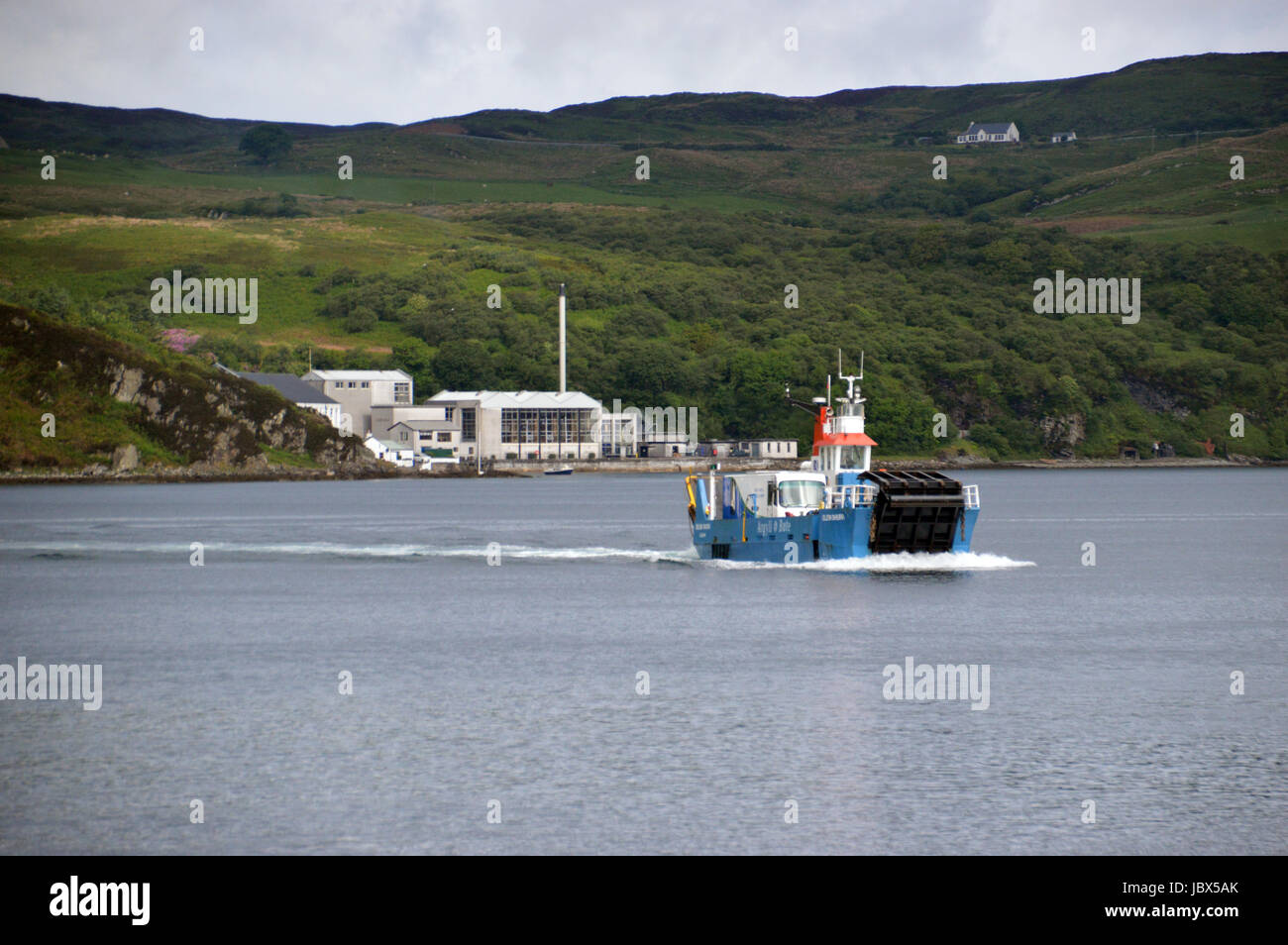 Il Islay per Jura traghetto (Eilean Dhiura) arrivando a Feolin con il Caol Ila distilleria di whisky in background. Isle of Jura, Isole scozzesi. Foto Stock