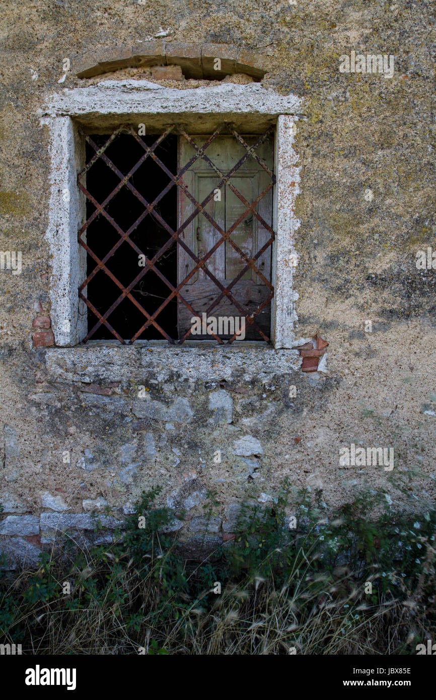 Finestra (finestra sbarrata)- Un agriturismo finestra con rivestimento bianco. La parte esterna è una superficie ruvida con peeling di intonaco. Foto Stock