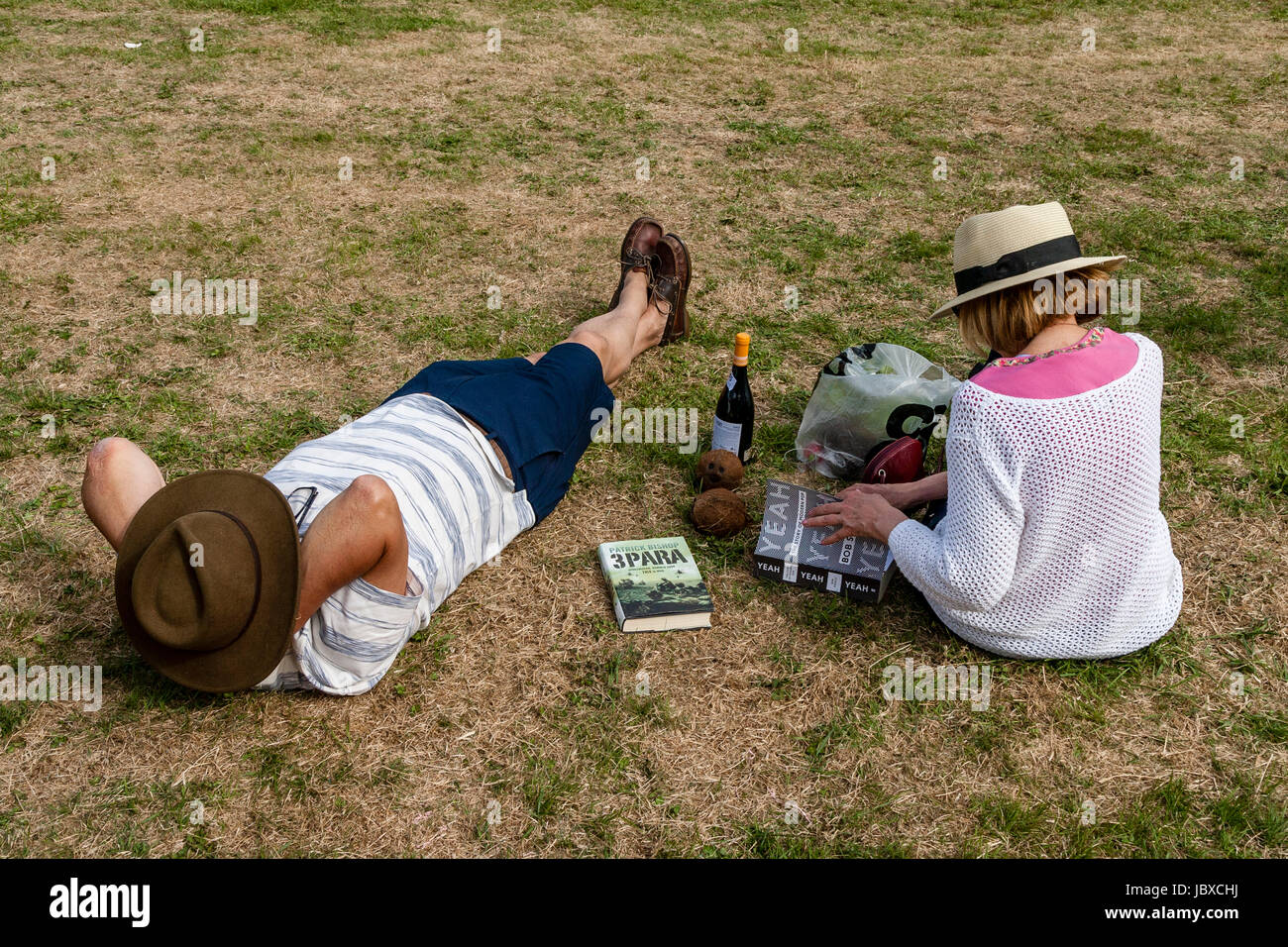Un paio di rilassarsi sulla Canonica campo al Jevington Fete, Jevington, East Sussex, Regno Unito Foto Stock