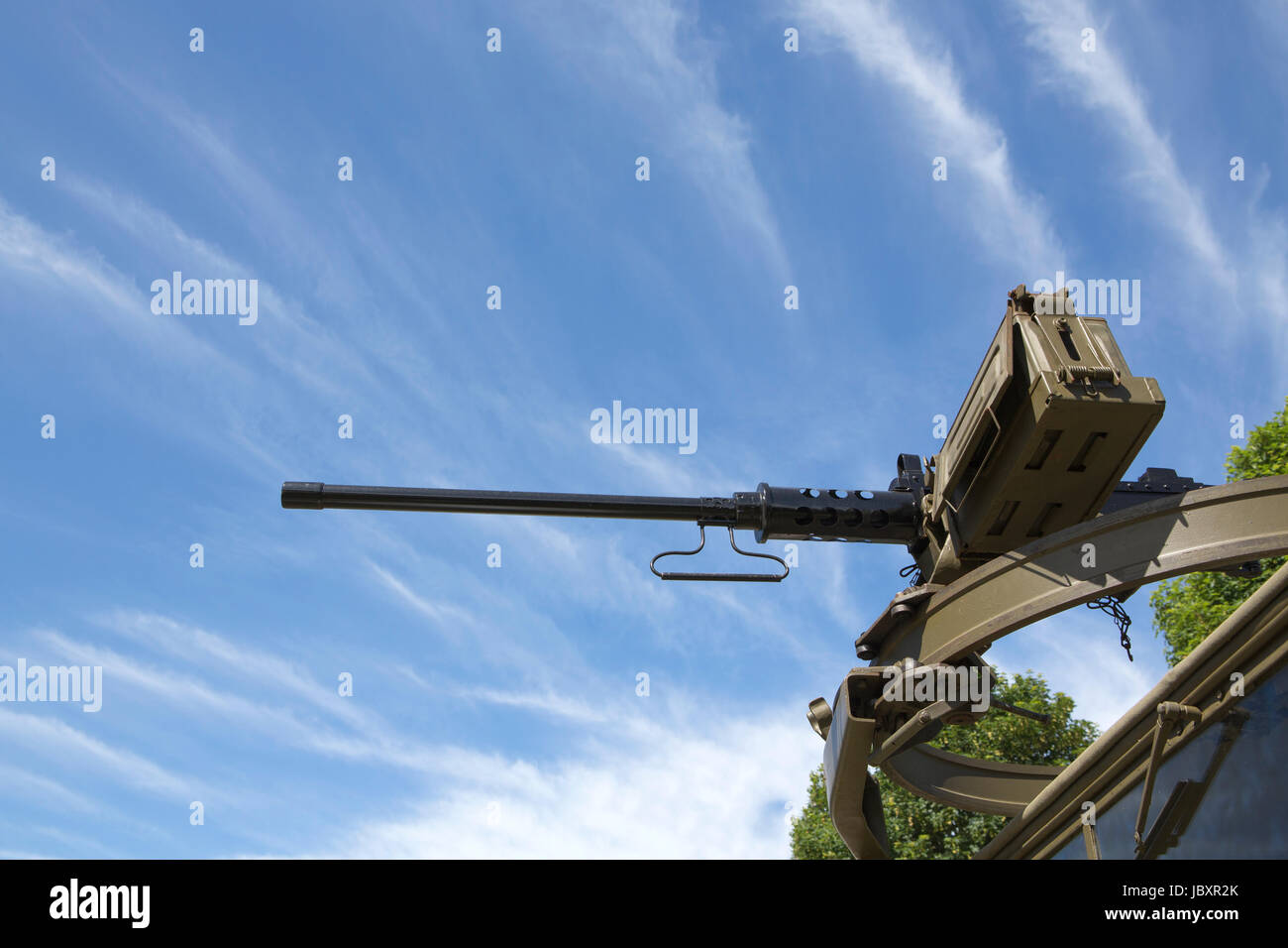 Vista guardando fino ad una M2 Browning mitragliatrice montata su un anello scarff sulla parte superiore di un camion militare. Cielo blu e il cloud striature dello sfondo. Foto Stock Vista guardando fino ad una M2 Browning mitragliatrice montata su un anello scarff sulla parte superiore di un camion militare. Cielo blu e il cloud striature dello sfondo. Foto Stock