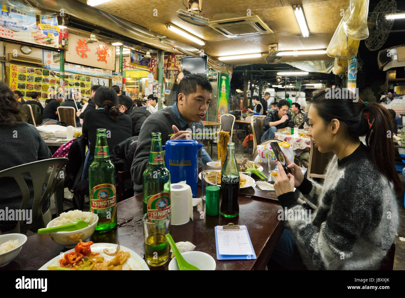 Vista orizzontale all'interno di un vivace ristorante streetfood a Hong Kong, Cina. Foto Stock