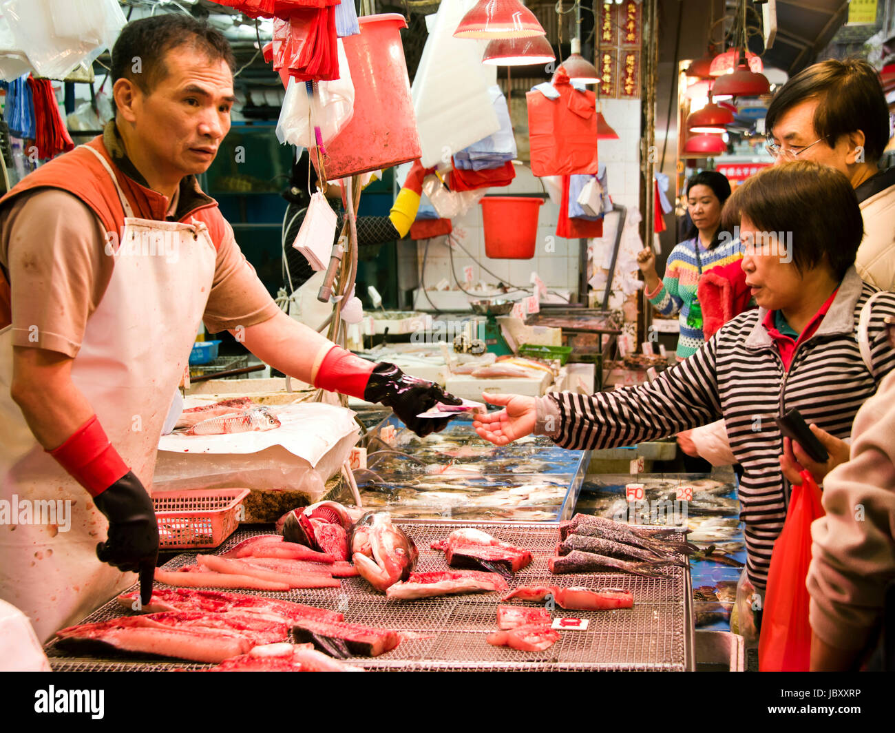 Vista orizzontale dei clienti serviti in una stalla di pescatori in un mercato bagnato a Hong Kong, Cina. Foto Stock