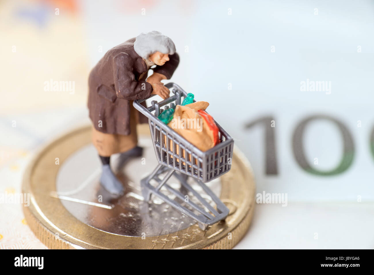 Vecchia donna con carrello su una moneta in euro con banconote Foto Stock
