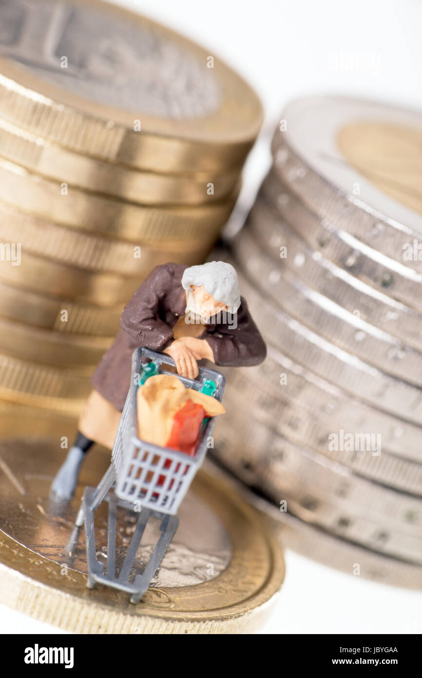 Vecchia donna con carrello su una moneta in euro Foto Stock