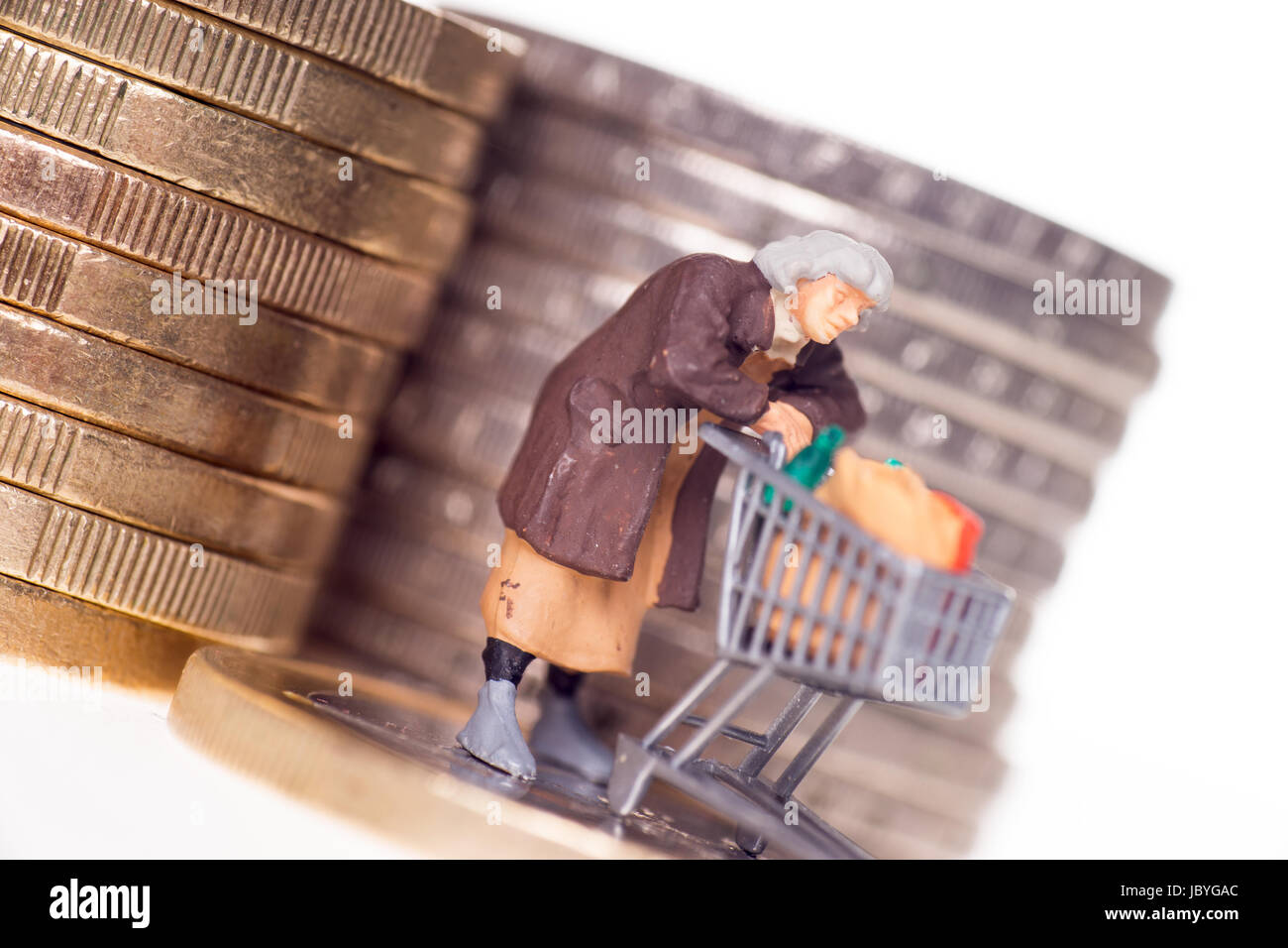 Vecchia donna con carrello su una moneta in euro Foto Stock